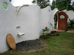 Muro exterior de arquitura organica con ducha de diseño y decorado con cristales artesanales.